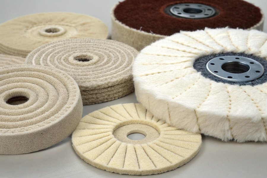 An assortment of different buffing wheels showing various materials like cotton, sisal, and felt