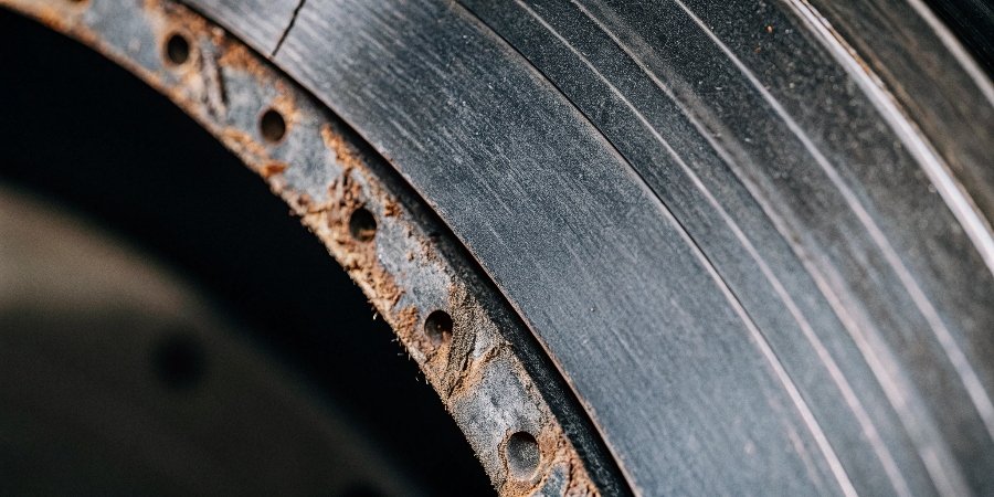 A close-up shot of a cut edge on stainless steel, showing rust spots caused by a contaminated wheel