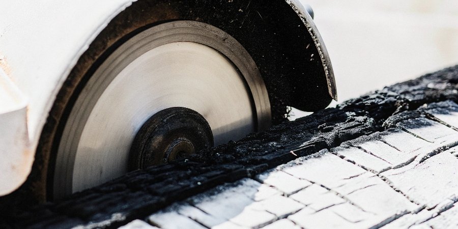 A thick grinding wheel (Type 27) jammed and stuck inside a badly burned piece of wood