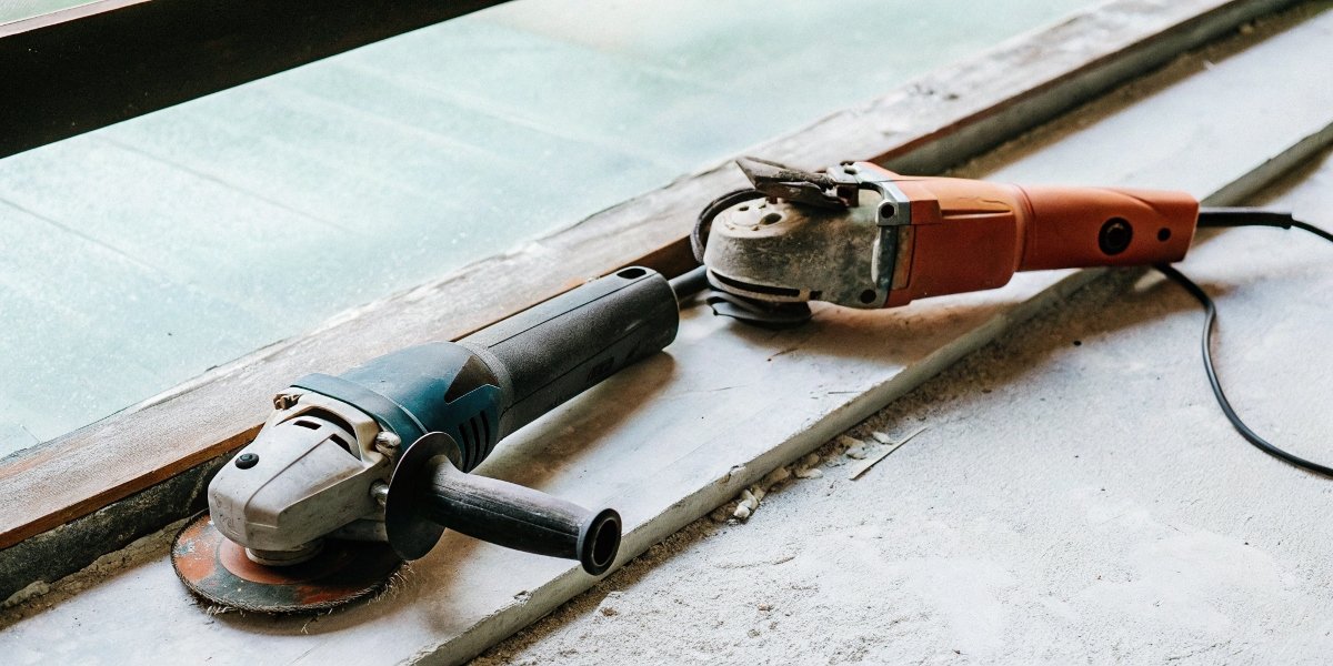 A small, versatile 4.5-inch angle grinder next to a large, powerful 9-inch angle grinder for comparison.