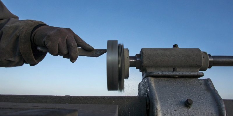 A safety officer pointing to a compliance checklist for a bench grinder