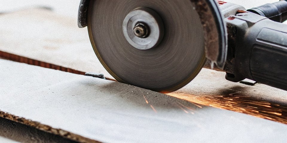 A large cutting disc shown next to a smaller angle grinder where the safety guard is visibly too small.