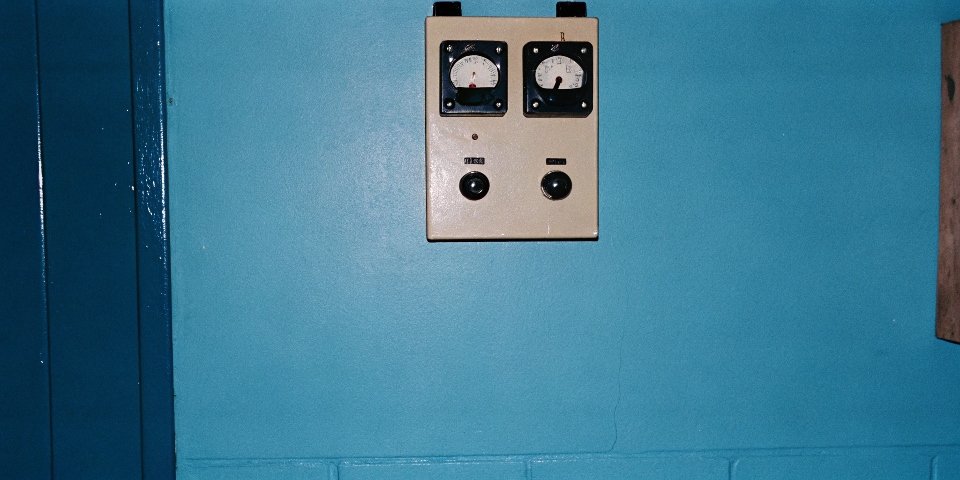An electric meter showing rising numbers, with a grinding workshop in the background.