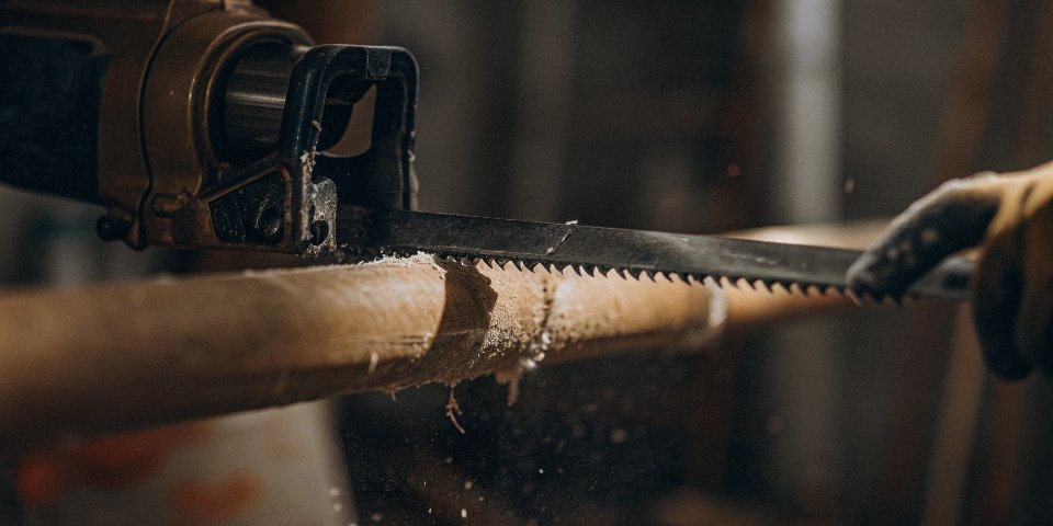 A reciprocating saw making a clean cut through a PVC pipe.