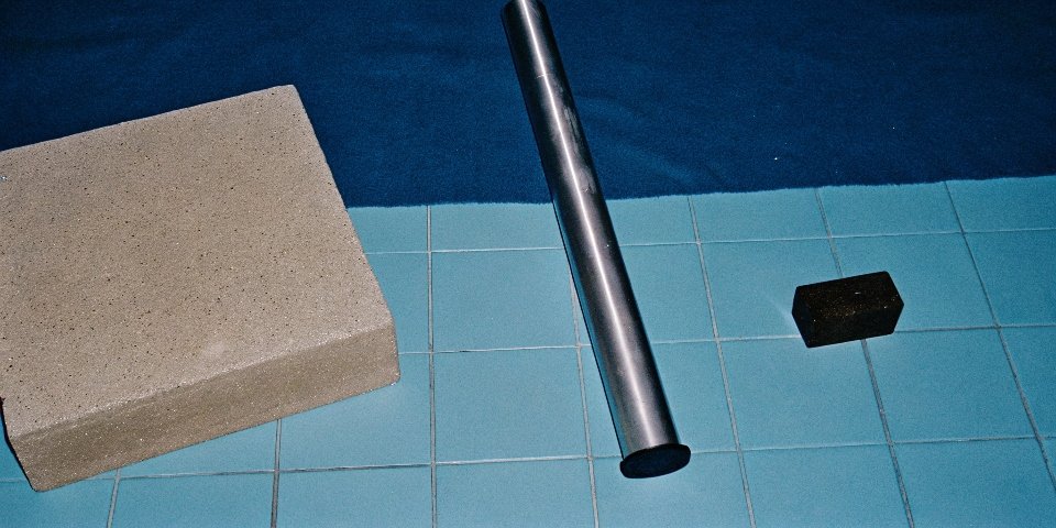 A collage of materials: a steel beam, an aluminum pipe, a concrete block, and a ceramic tile.