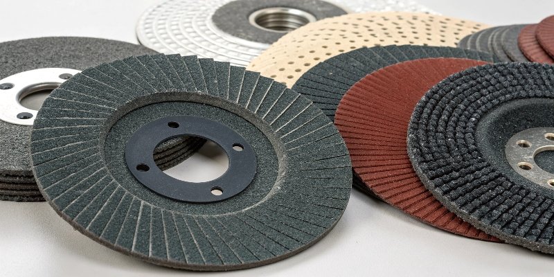 An assortment of grinder discs including cutting discs, grinding wheels, and flap discs.