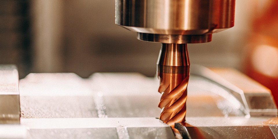 A close-up of a carbide tool cutting a hard metal with a clean finish