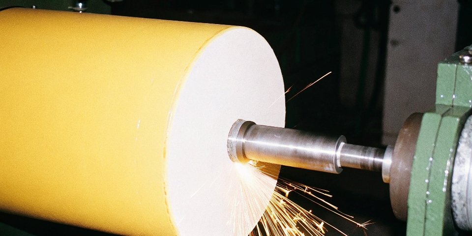 A CBN grinding wheel creating sparks as it produces a perfect finish on a hardened steel gear.
