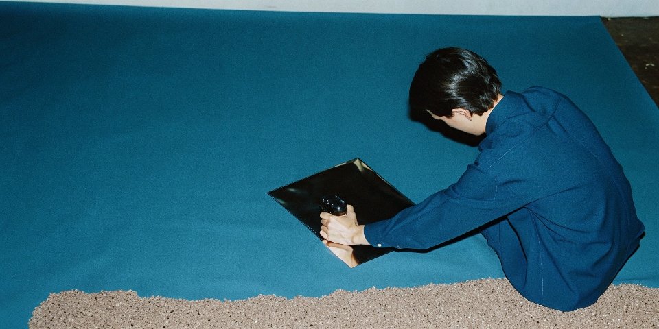 An engineer inspecting a mirror-smooth metal surface from a grinder vs. a pile of rough-cut plastic pellets.