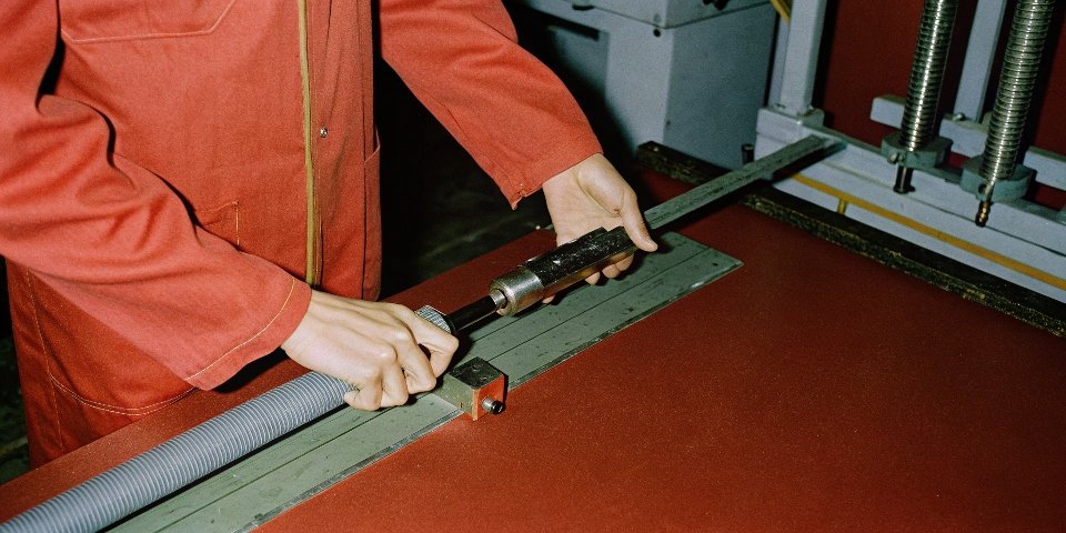 A machinist carefully measuring a rod journal with a micrometer after grinding.