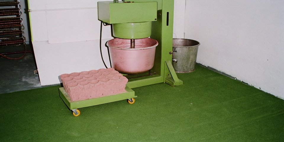 A factory scene with a large mixer, a hydraulic press, and an industrial oven.