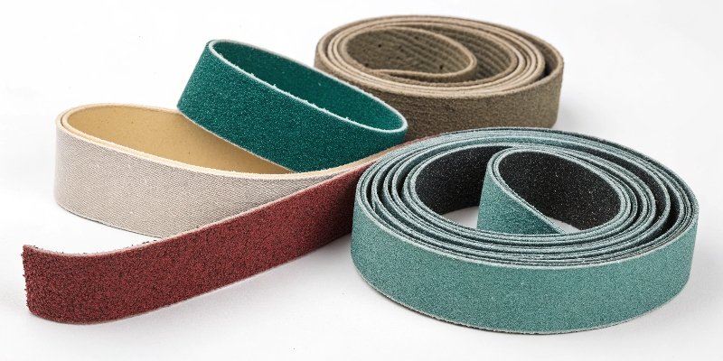 An assortment of different colored sanding belts made from various materials
